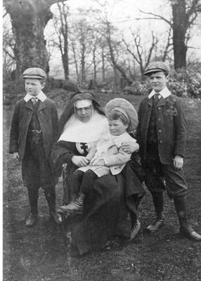 Nun and three boys in grounds of Clayton Hall