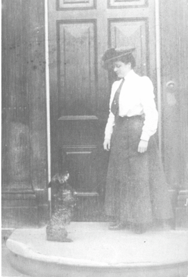 Lady at doorway to Clayton Hall with dog