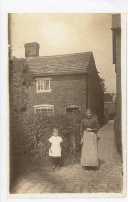 Woman and child outside cottage Eccleston. Lancashire.